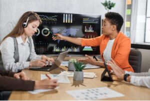 A group of business professionals engaged in discussion around a conference table, collaborating on a project.