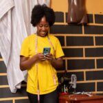 A woman wearing a yellow shirt stands next to a man, engaged in a conversation about digital marketing in Uganda.